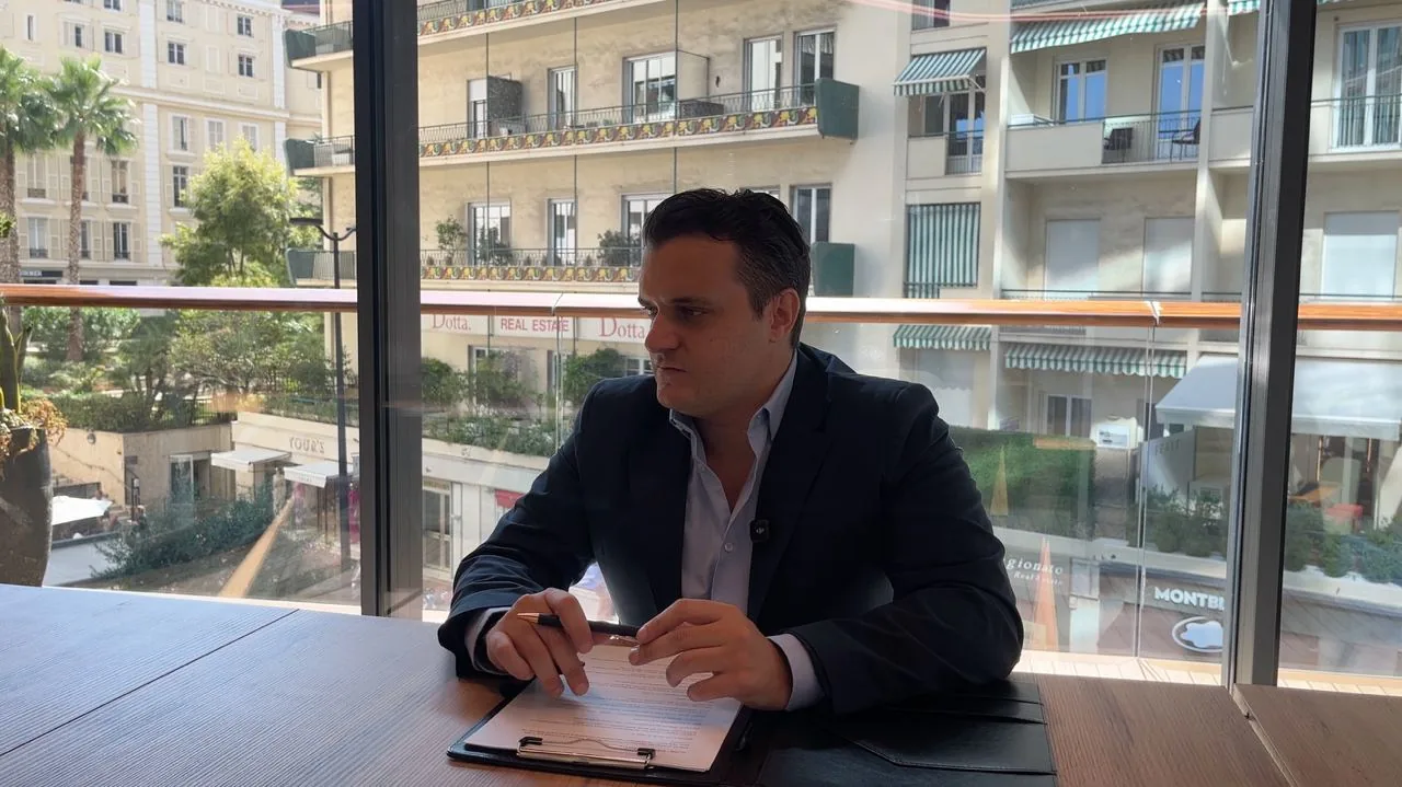 Emilio Salerno al tavolo di lavoro, davanti alla vetrata su Monte-Carlo